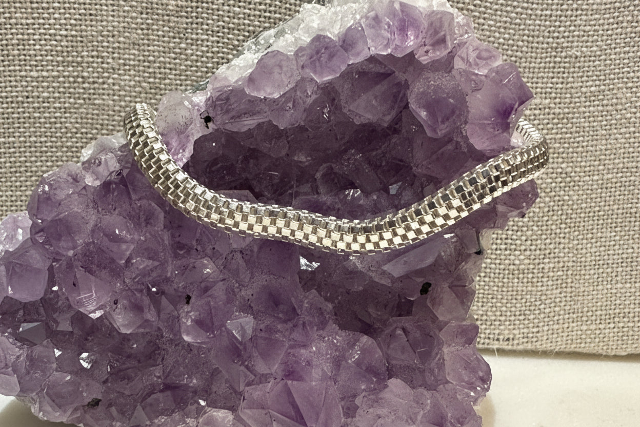 Silver chain necklace on a purple crystal