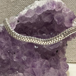 Silver chain necklace on a purple crystal