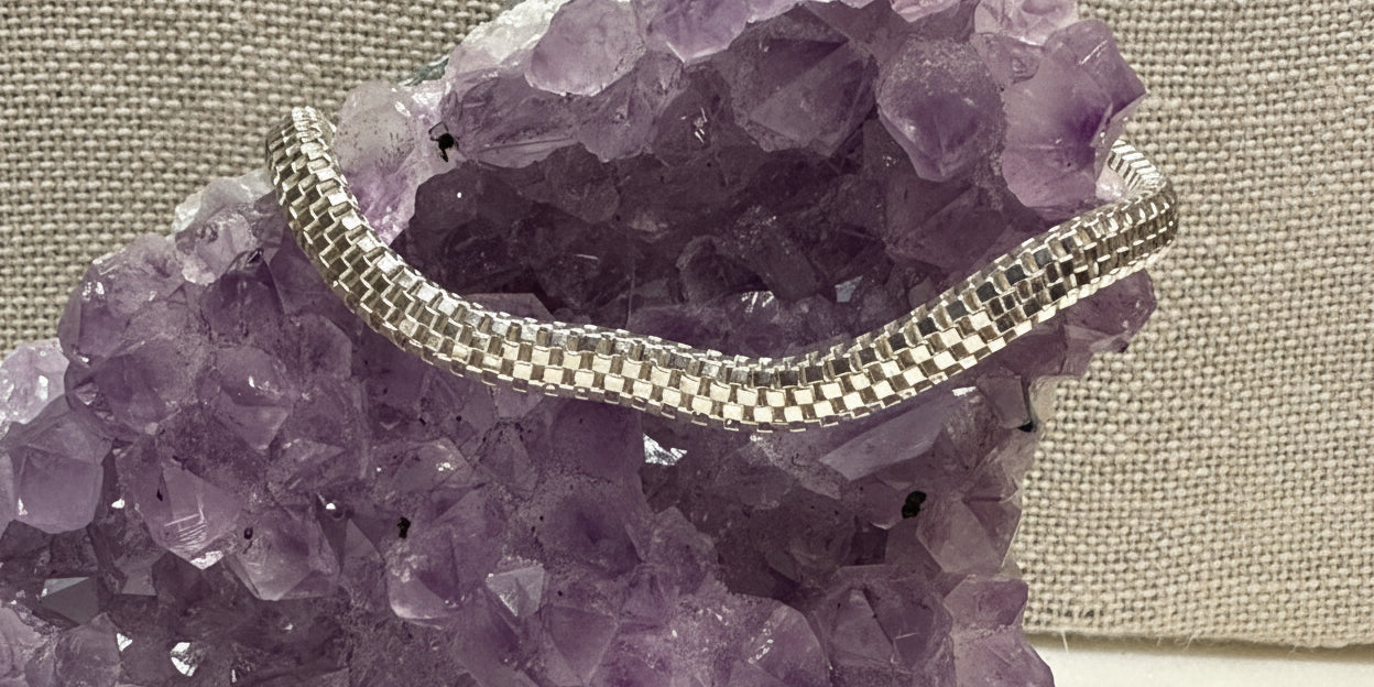 Silver chain necklace on a purple crystal